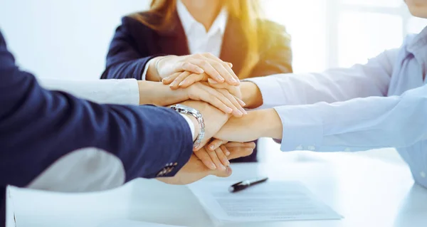 Geschäftsteam zeigt im sonnigen Büro Geschlossenheit mit den Händen. Gruppe von Menschen, die sich die Hände reichen und das Konzept der Freundschaft und Teamarbeit repräsentieren — Stockfoto