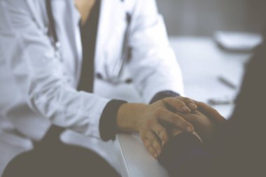 Bilinmeyen kadın doktor, kadın hastasına güvence veriyor, yakın plan. Doktor bir kadına danışmanlık yapıyor ve tavsiyelerde bulunuyor. Tıbbi ahlak ve güven kavramları. Tıpta empati