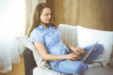 İş kadını Covid-19 karantinası sırasında dizüstü bilgisayarla çalışıyor. Coronavirus salgını sırasında evde konsept kal