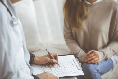 Bilinmeyen kadın doktor ve hasta içeride otururken sağlık muayenesini tartışıyorlar. Coronavirus salgını ve kendini izolasyon karantinası süresince evde kal