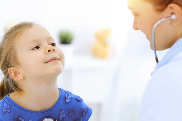 Γιατρός εξετάζει ένα κοριτσάκι με στηθοσκόπιο. Χαρούμενος χαμογελαστός ασθενής στη συνηθισμένη ιατρική εξέταση. Έννοιες ιατρικής και υγειονομικής περίθαλψης — Φωτογραφία Αρχείου