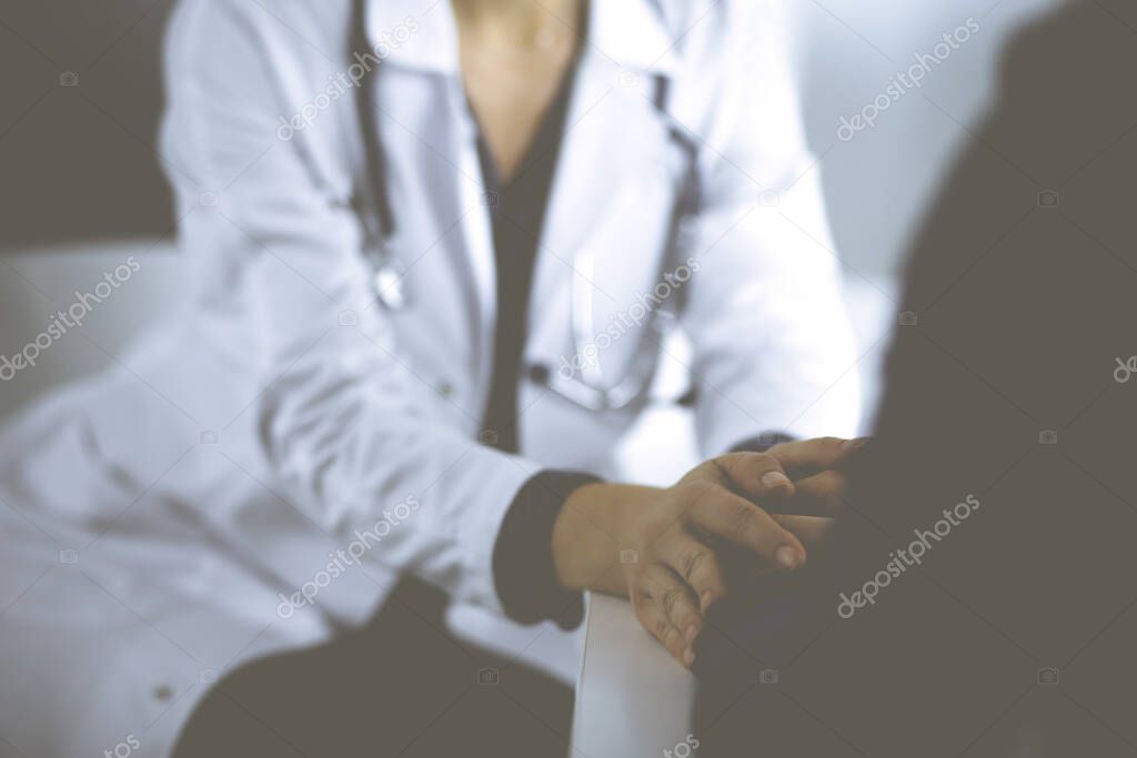 Unknown woman-doctor is reassuring her female patient, close-up. Physician is consulting and giving some advices to a woman. Concepts of medical ethics and trust. Empathy in medicine