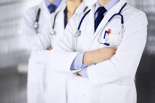 En grupp moderna läkare som står som ett team med korsade armar och stetoskop på sjukhusets kontor. Läkare redo att undersöka och hjälpa patienter. Medicinsk hjälp, sjukförsäkring, bästa obehag — Stockfoto