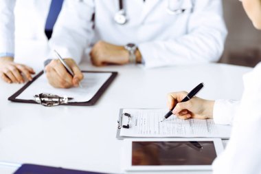 Bilinmeyen bir grup doktor masanın başında oturmuş modern hastane ofisindeki hastalıkları veya hastalıkları tartışıyorlar. Coronavirus dengeleyici, ilaç konseptinde hasta yardımı