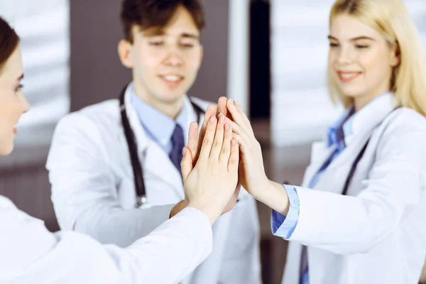 Un gruppo di medici moderni si uniscono e si danno cinque a vicenda come segno di un forte lavoro di squadra e pronti ad aiutare i pazienti. Contro il coronavirus e il concetto di medicina — Foto Stock