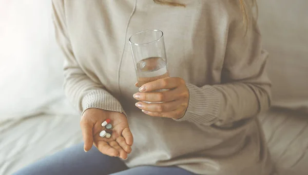 Gros plan femme tenant des pilules temps pour prendre des médicaments, guérir les maux de tête. Concept de médecine pendant l'auto-isolement et la pandémie de coronavirus — Photo