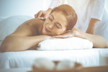 Güzel esmer kadın gözleri kapalı sırt masajından hoşlanıyor. Spa ve tıp konsepti