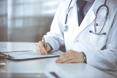 Bilinmeyen erkek doktor, klinikteki ilaç geçmişi kayıtlarıyla birlikte yakın planda oturuyor. İşteki genç doktor. Mükemmel sağlık hizmeti, tıp konsepti