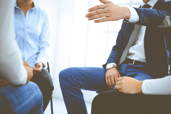 Группа людей, сидящих в кругу во время терапии. Встреча бизнес-команды, участвующей в тренинге