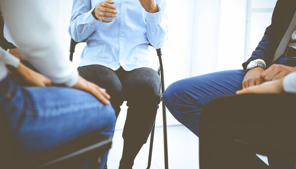 Группа людей, сидящих в кругу во время терапии. Встреча бизнес-команды, участвующей в тренинге