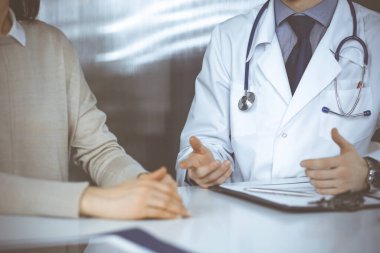 Bilinmeyen erkek doktor ve hasta kadın klinikte otururken bir şey tartışıyorlar. Hastanedeki en iyi sağlık hizmeti, ilaç, salgın durdurma.