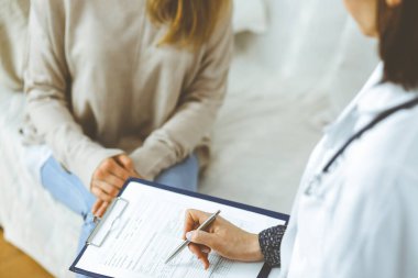 Bilinmeyen kadın doktor ve hasta içeride otururken sağlık muayenesini tartışıyorlar. Coronavirus salgını ve kendini izolasyon karantinası süresince evde kal