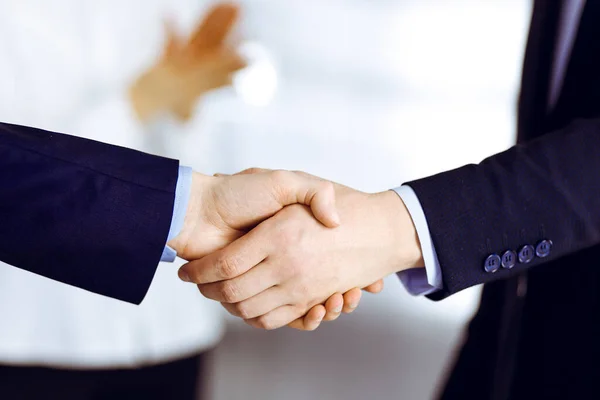 Affärsmän skakar hand vid möte eller förhandling, närbild. En grupp okända affärsmän och en kvinna som står på ett modernt kontor. Teamwork, partnerskap och handskakning — Stockfoto