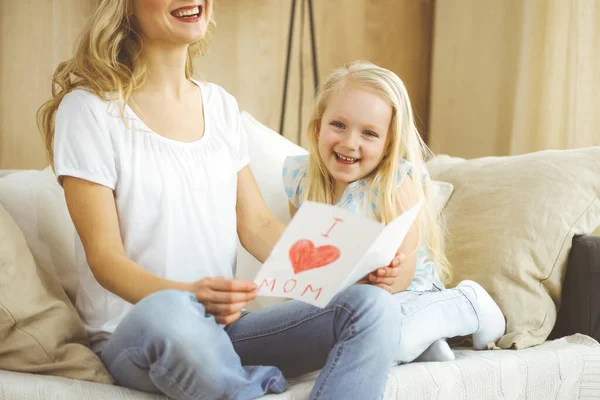 Glücklicher Muttertag. Die Tochter gratuliert der Mutter und überreicht ihr eine Postkarte mit Herzzeichnung. Familien- und Kindheitskonzepte — Stockfoto