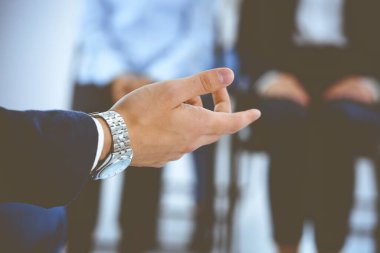 İş adamı bir grup insana sunum yapıyor, yakın plan. Sözcü iş arkadaşlarına seminer ya da iş eğitimi veriyor. Takım çalışması ve koçluk konsepti