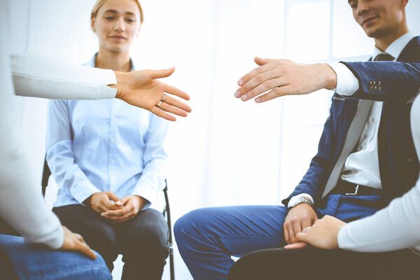 Группа людей, сидящих в кругу во время терапии. Встреча бизнес-команды, участвующей в тренинге