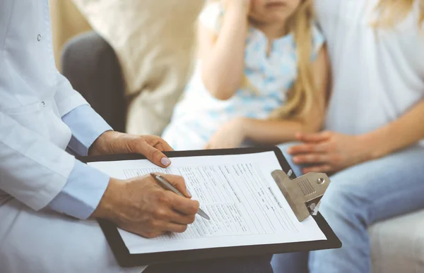 Dokter en patiënt. Kinderarts die klembord gebruikt terwijl ze het kleine meisje onderzoekt met haar moeder thuis. Ziek en ongelukkig kind bij medisch onderzoek. Geneesmiddelenconcept — Stockfoto