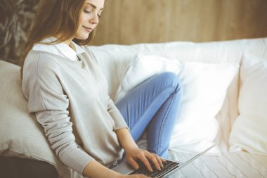 Covid-19 karantinası sırasında dizüstü bilgisayarda çalışan genç bir kadın. Coronavirus salgınında ev konseptinde kal