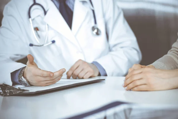 Médico masculino desconocido y mujer paciente discutiendo algo mientras está sentado en la clínica. El mejor servicio médico en hospital, medicina, parada pandémica — Foto de Stock