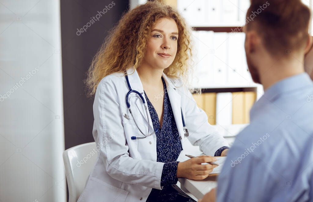 Female doctor and patient discussing current health examination while sitting in sunny clinic. Medicine concept