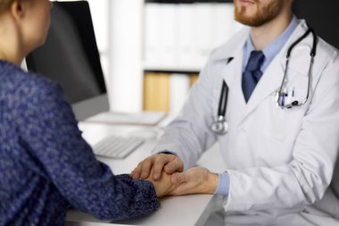 Dost canlısı doktor, kadın hastasına güvence veriyor, yakın plan. Tıp etiği ve güven kavramı, tıp teması