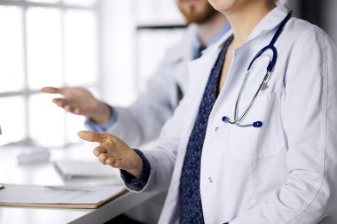 İki doktor oturup el sıkışmak ya da hayat kurtarmak için yardım eli uzatıyorlar. Tıbbi yardım, viral enfeksiyon ve tıp konseptiyle mücadele