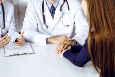 Bilinmeyen erkek-doktor, kadın hastasına güvence veriyor, yakın plan. İki doktor kadınlara danışmanlık yapıyor ve tavsiyelerde bulunuyor. Mükemmel tıbbi hizmet, Coronavirus salgını sırasında tıpta empati. Kapalı