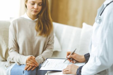 Bilinmeyen kadın doktor ve hasta içeride otururken sağlık muayenesini tartışıyorlar. Coronavirus salgını ve kendini izolasyon karantinası süresince evde kal