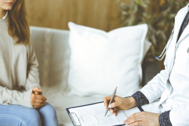 Bilinmeyen kadın doktor ve hasta içeride otururken sağlık muayenesini tartışıyorlar. Coronavirus salgını ve kendini izolasyon karantinası süresince evde kal