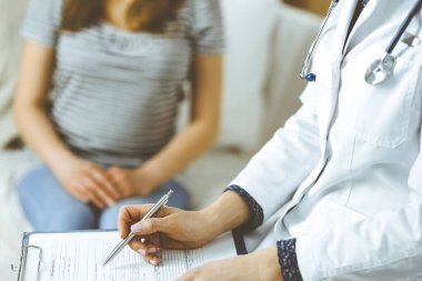 Bilinmeyen kadın doktor ve hasta sıcak oturma odasında otururken sağlık muayenesini tartışıyorlar. Coronavirus salgını ve kendini izolasyon karantinası süresince evde kal