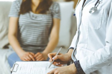 Bilinmeyen kadın doktor ve hasta sıcak oturma odasında otururken sağlık muayenesini tartışıyorlar. Coronavirus salgını ve kendini izolasyon karantinası süresince evde kal
