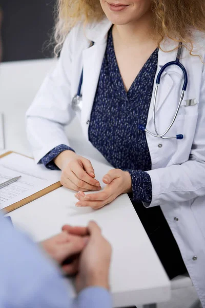 Médico femenino y paciente masculino discutiendo el examen de salud actual mientras está sentado en la clínica, primer plano — Foto de Stock