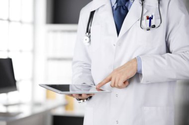 Klinikte tablet bilgisayar kullanan erkek doktor, yakın plan. Hastanede mükemmel bir tıbbi hizmet.