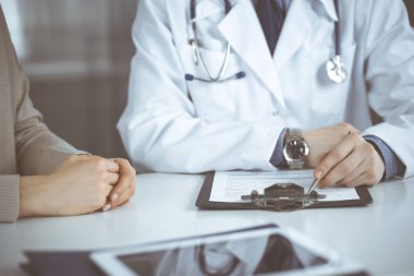 Bilinmeyen erkek doktor ve hasta kadın klinikte oturup dosya kullanırken bir şey tartışıyorlar. Hastanedeki en iyi sağlık hizmeti, ilaç, salgın durdurma.