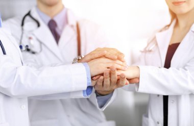 Bir grup modern doktor el ele verip hastalara yardım etmeye hazır. Tıpta takım çalışması, Coronavirus karşı koyma konsepti