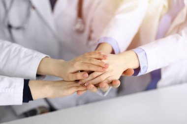 Bir grup modern doktor el ele vererek bir çember oluşturdu. Coronavirus salgını sırasında tıpta takım çalışması, covid 2019