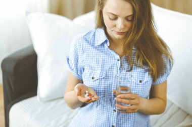 Kapalı çekim kadın ilaç almak için zaman tutuyor, baş ağrısı için tedavi, yüksek tansiyon veya kolesterol seviyesinde ağrı kesici ilaçlar. Tıp konsepti