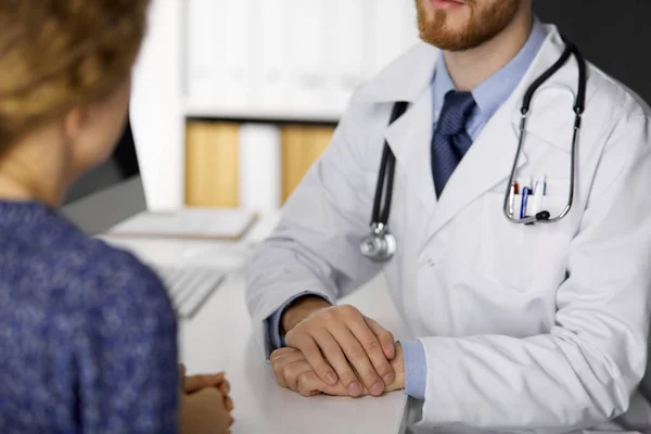 Unknown male doctor and patient woman discussing current health examination while sitting and using tablet computer in clinic, close-up — Stock Photo, Image