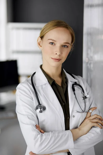 Amichevole dottoressa sorridente in piedi in clinica. Ritratto di donna medico amichevole. Servizio medico perfetto in ospedale — Foto Stock