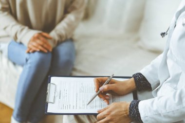 Bilinmeyen kadın doktor ve hasta içeride otururken sağlık muayenesini tartışıyorlar. Coronavirus salgını ve kendini izolasyon karantinası süresince evde kal