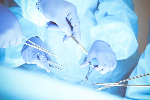 Un grupo de cirujanos está operando en el hospital, cerca de las manos. Concepto de salud — Foto de Stock