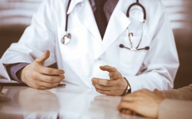 Bilinmeyen erkek doktor ve hasta kadın klinikte oturup dosya kullanırken bir şey tartışıyorlar. Hastanedeki en iyi sağlık hizmeti, ilaç, salgın durdurma.