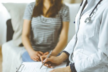 Bilinmeyen kadın doktor ve hasta sıcak oturma odasında otururken sağlık muayenesini tartışıyorlar. Coronavirus salgını ve kendini izolasyon karantinası süresince evde kal