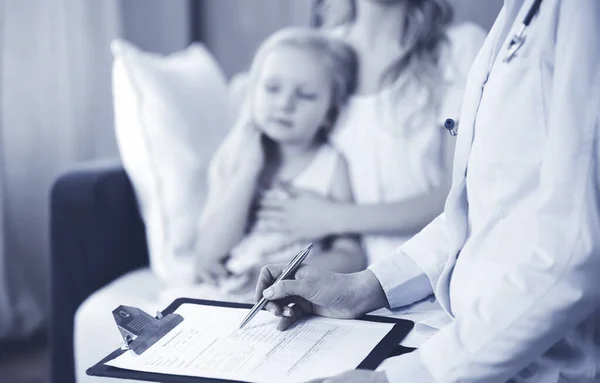 Doctor y paciente. Pediatra usando portapapeles mientras examina a la niña con su madre en casa. Niña enferma e infeliz en el examen médico. Concepto de medicina —  Fotos de Stock