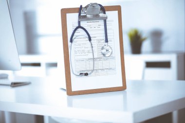 Stetoskop ve ilaç geçmişi olan dosya doktorların çalışma yerinde masanın üstünde. İlaç ve sağlık hizmetleri kavramı