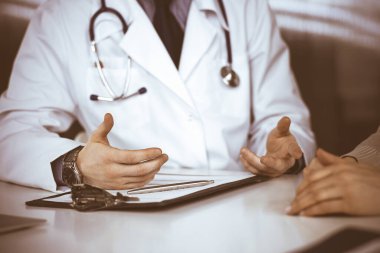 Bilinmeyen erkek doktor ve hasta kadın klinikte otururken bir şey tartışıyorlar. Hastanedeki en iyi sağlık hizmeti, ilaç, salgın durdurma.