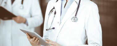 Klinikte dururken elinde tablet bilgisayar tutan kimliği belirsiz bir kadın doktor. Coronavirüs salgını sırasında ilaç kavramı