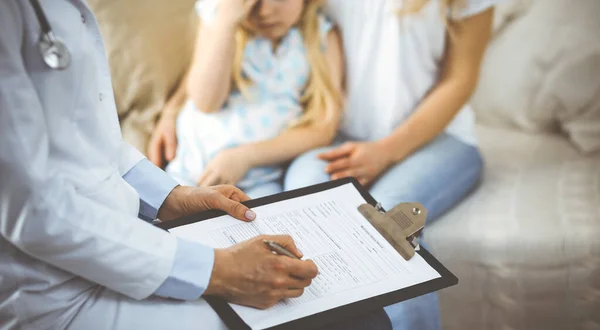 Dokter en patiënt. Kinderarts die klembord gebruikt terwijl ze het kleine meisje onderzoekt met haar moeder thuis. Ziek en ongelukkig kind bij medisch onderzoek. Geneesmiddelenconcept — Stockfoto