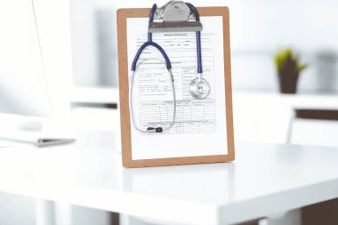 Stetoskop ve ilaç geçmişi olan dosya doktorların çalışma yerinde masanın üstünde. İlaç ve sağlık hizmetleri kavramı