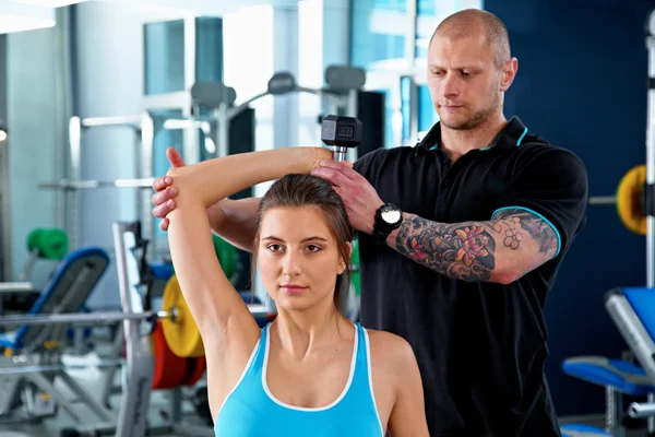 Mulher com personal trainer no ginásio — Fotografia de Stock